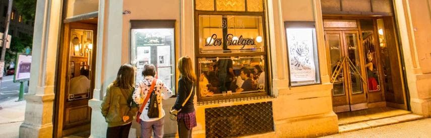 calle de barrio tradicional en Buenos Aires con restaurantes locales y bodegones
